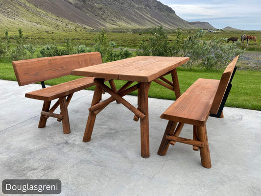 Ásdís – útihúsgagnasett úr Douglasgreni, borð og tveir bekkir með rúnuðum fótum á steyptu plani í íslenskri náttúru.