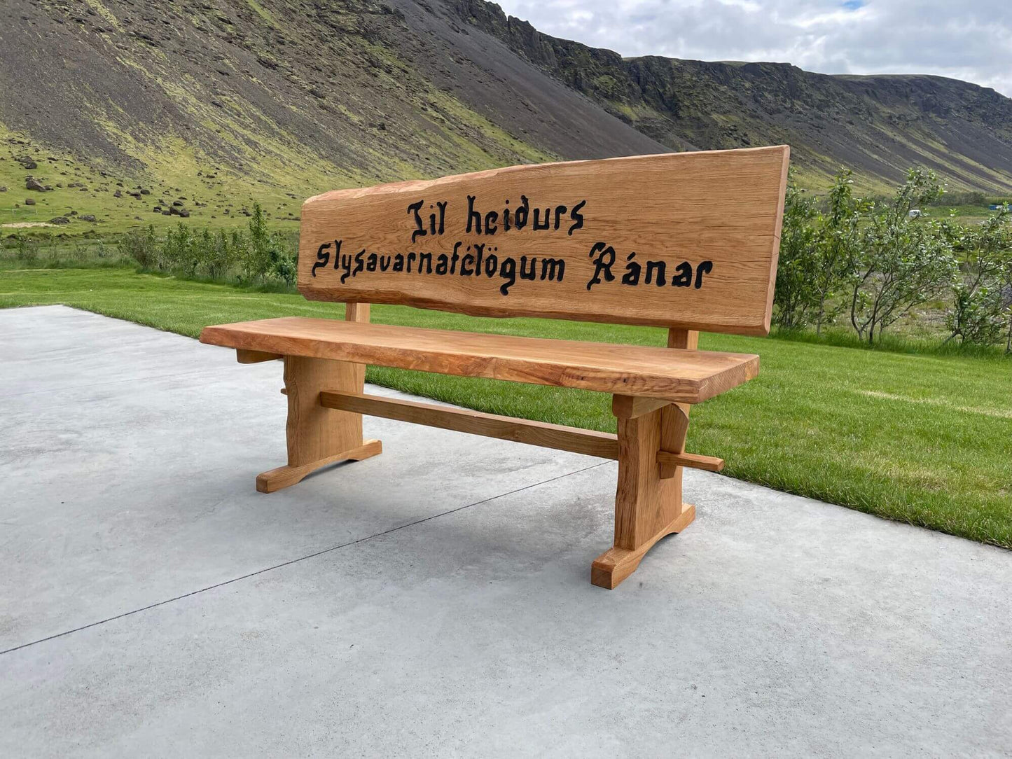 Sérmerktur garðbekkur úr Douglas harðviði með áletrun „Til heiðurs Slysavarnafélögum Ránar“, einstaklega falleg viðarsmíð.