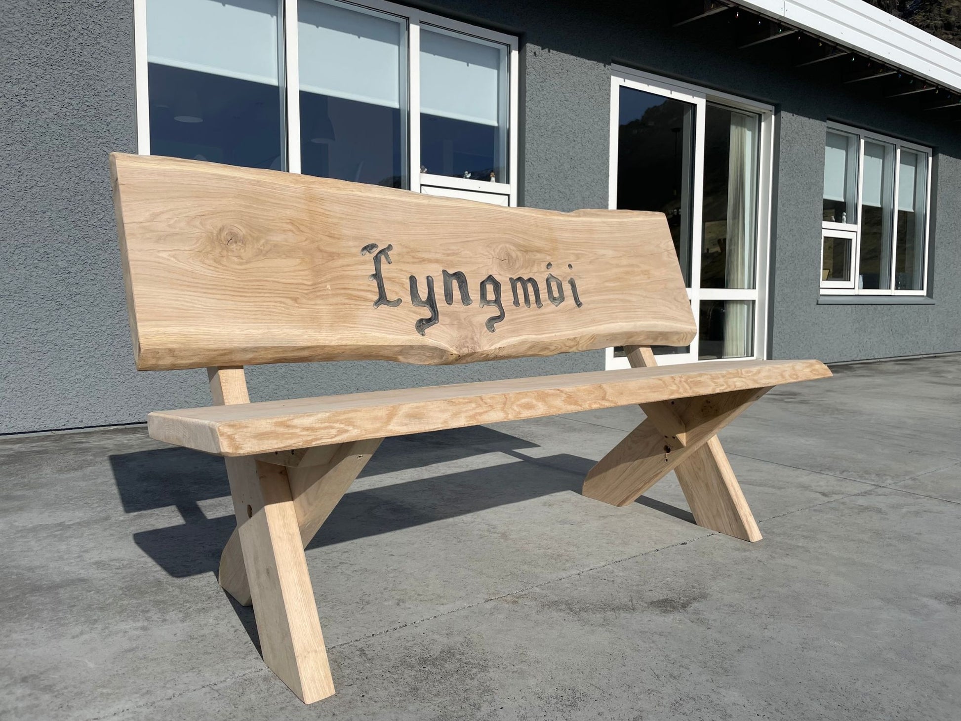 Bekk­ur með krossfótum úr ljósri eik og áritun í baki – Glúmur frá Lyngur.is, handsmíðaður í Danmörku úr skandinavískum harðviði, hannaður fyrir íslenska náttúru og norræna fegurð.