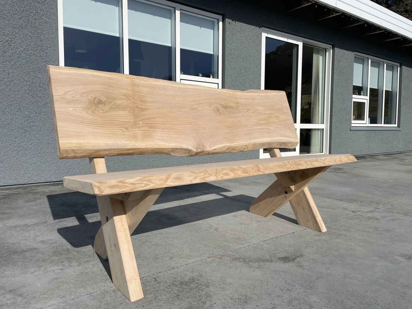 Garðbekkur með krossfótum úr ljósri eik – Glúmur frá Lyngur.is, handsmíðaður í Danmörku úr gæða harðviði úr skógum Evrópu, hannaður fyrir íslenskt veðurfar og útivist.