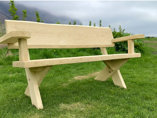 Handsmíðaður útibekkur úr eik harðviði með örmum og krossfótum, náttúrulegur litur og norrænt yfirbragð.