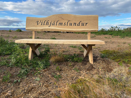 Sérmerktur garðbekkur úr eik með grafna áletrun „Vilhjálmslundur“, handsmíðaður útibekkur úr harðviði.